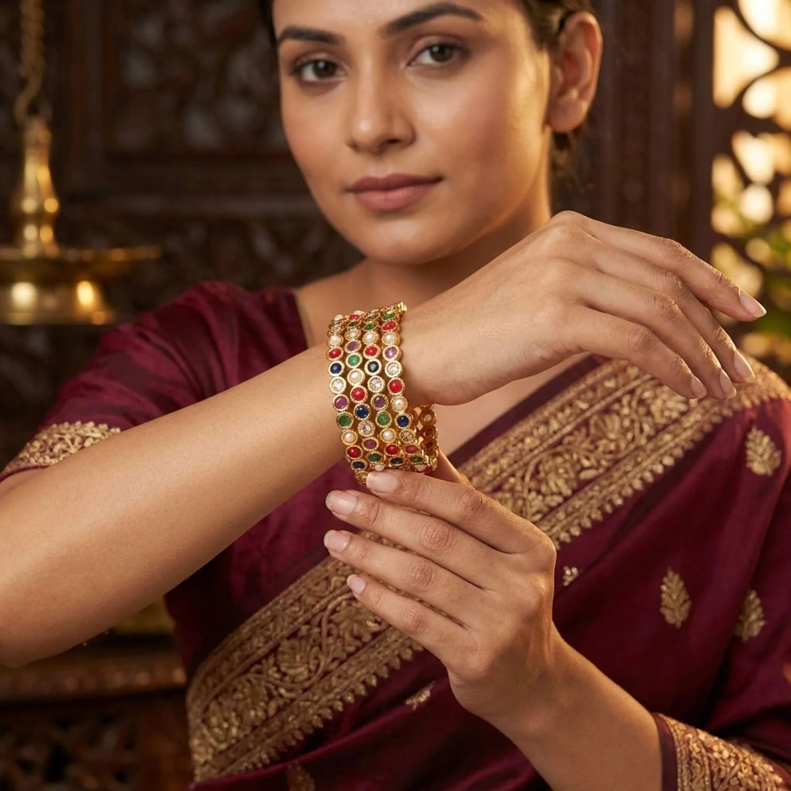 Model in a maroon outfit wearing a stack of multicolour stone bangles