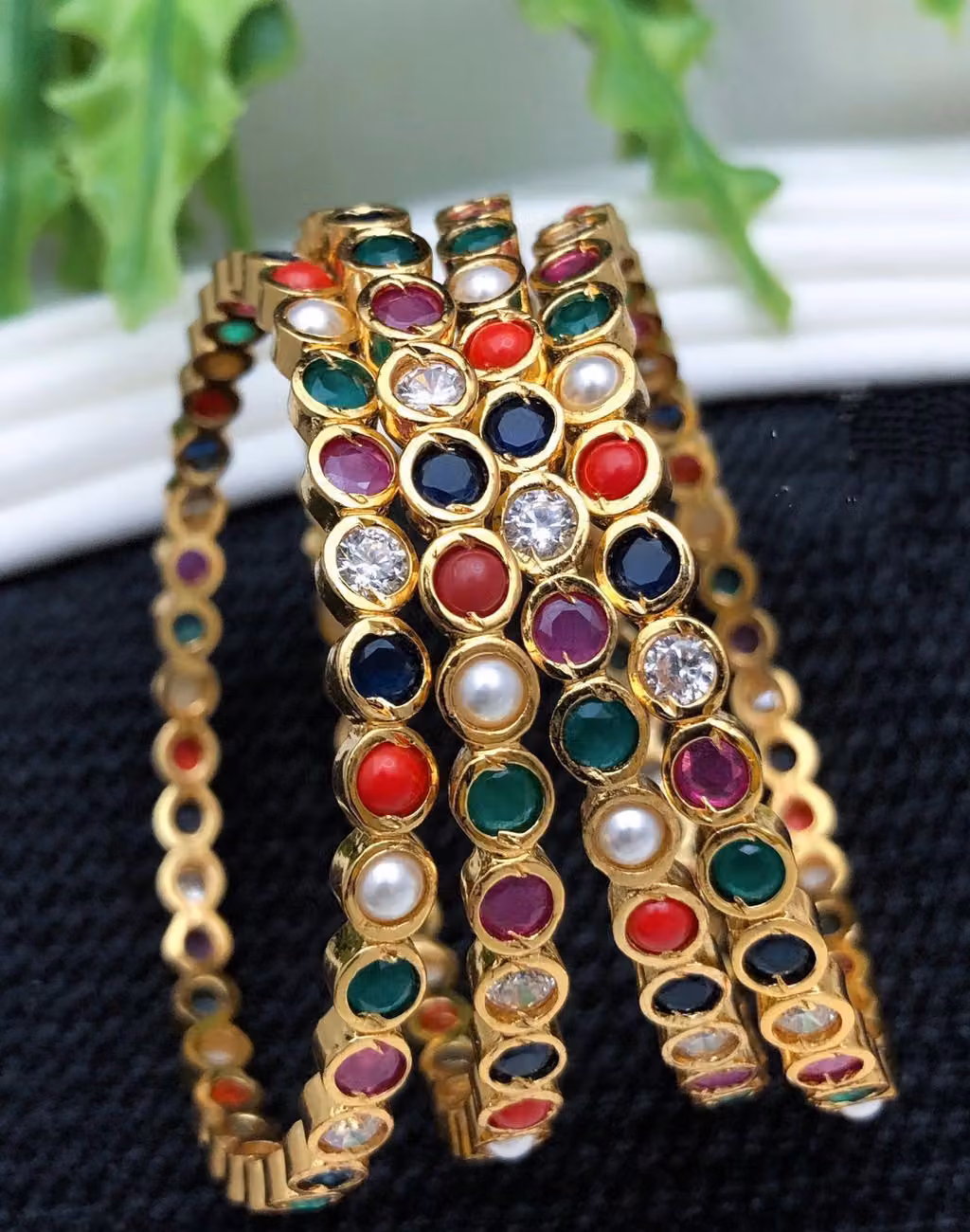 Upright arrangement of gold-tone bangles with multicolour round stones